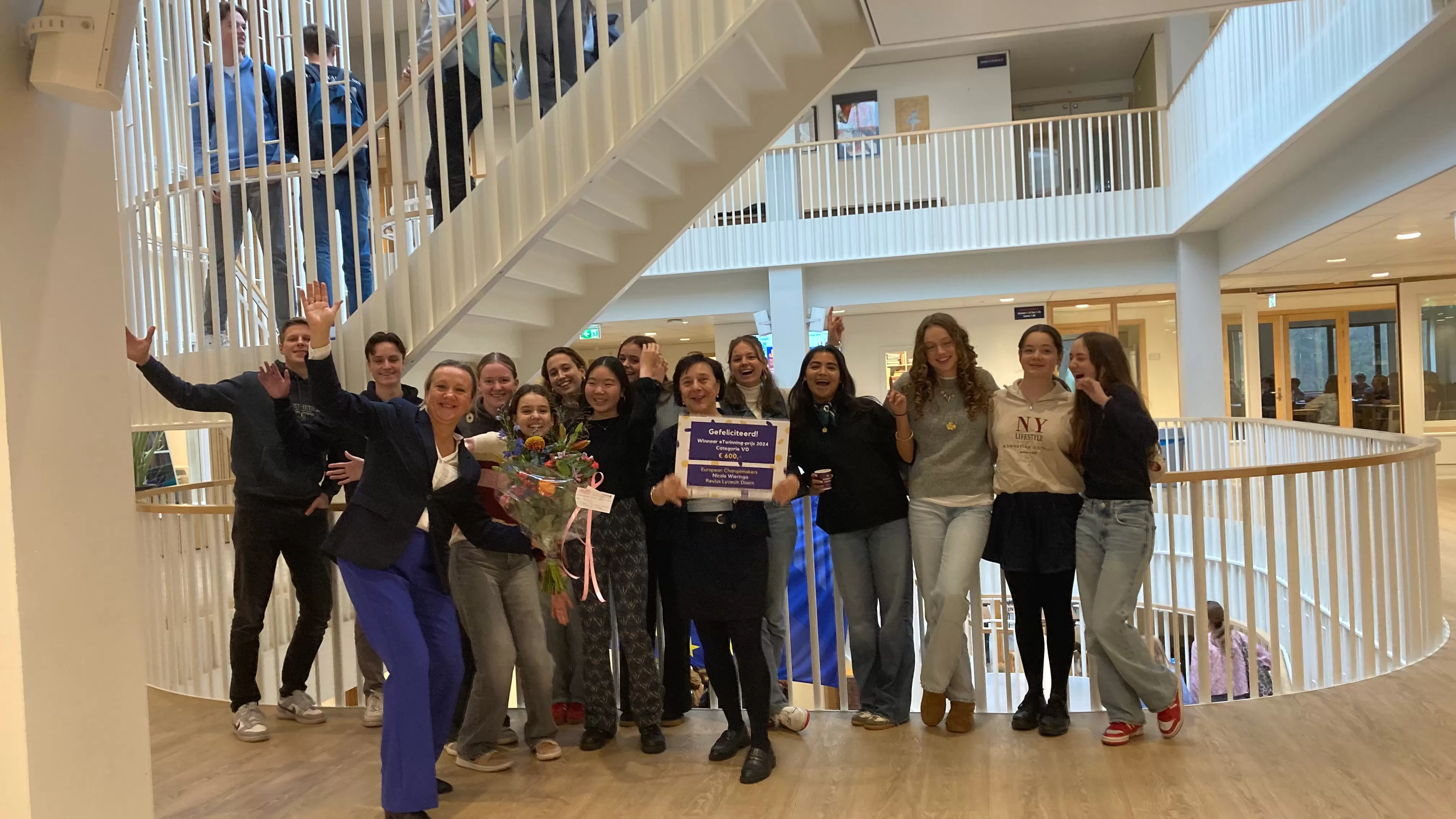 Leerlingen Voortgezet Onderwijs en ambassadeur Nicole Wieringa op het Revius Lyceum in Doorn met de nationale eTwinning prijs en bloemen.